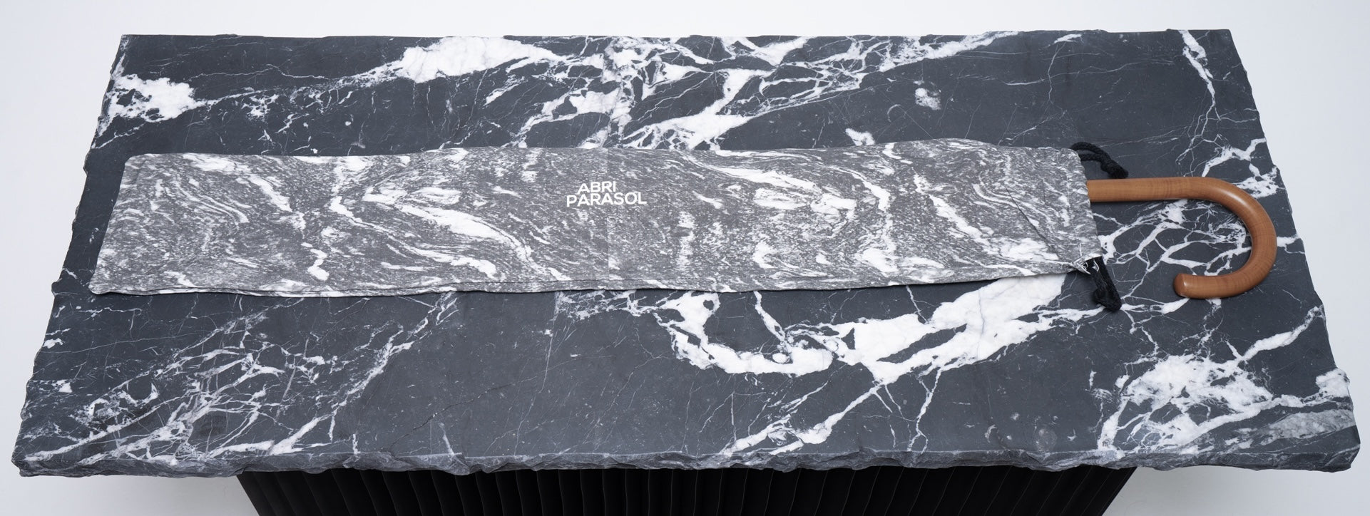 Marbled umbrella on a marble surface with 'Parasol' branding.